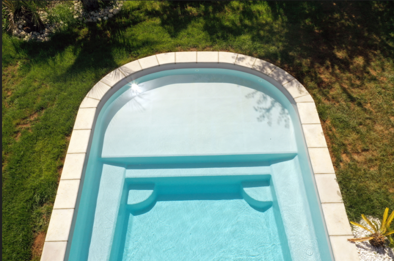Piscine au sel automatique connecté Piscine coque polyester avec une grande plage immergé grise moderne originale à Fréjus dans le Var 83