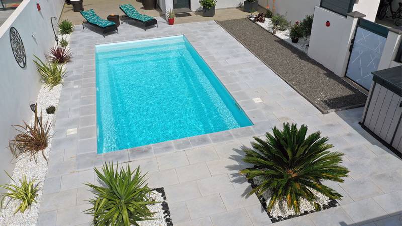 Flamingo : Piscine coque fond incliné progressif avec escalier sur la largeur et banquette dans le Var